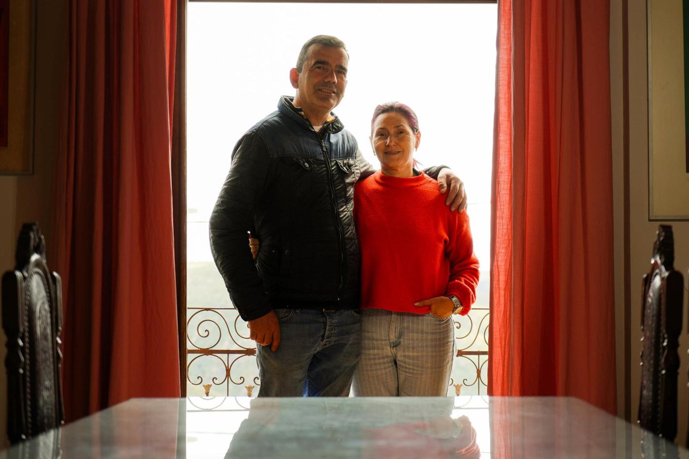 Emília e Pedro à janela da sala, com o vale ao fundo