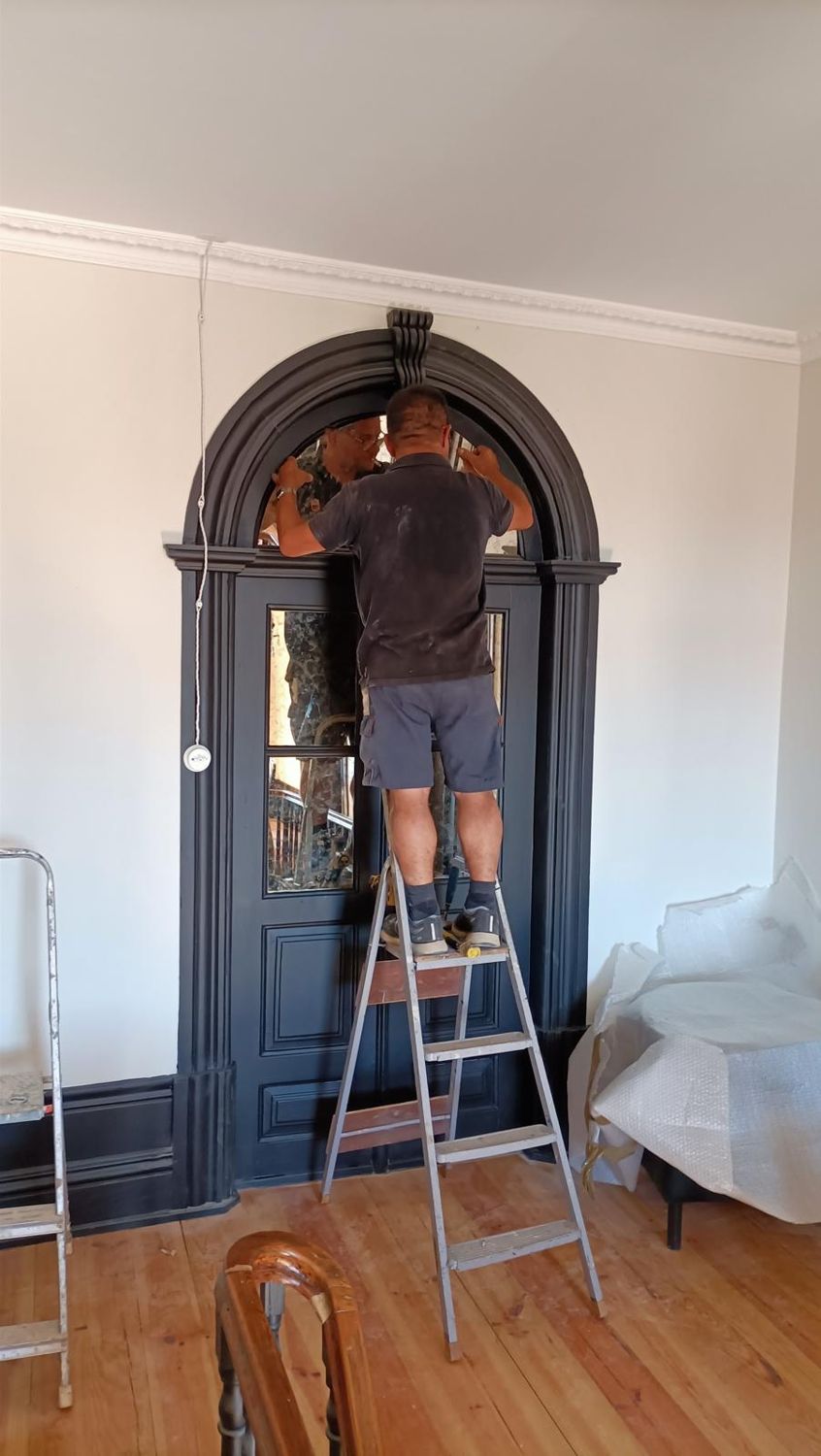 A colocar os espelhos na porta em arco do patamar