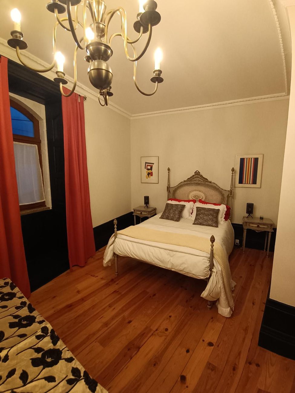 Quarto com cortinas vermelhas e soalho de pinho